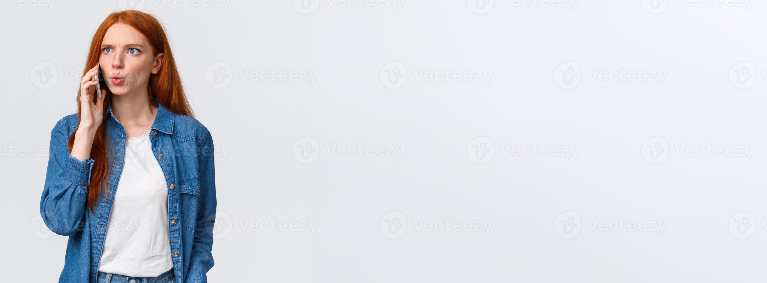 You say what. Intense and frustrated, confused redhead woman getting tensed and distressed hearing some bad news on phone, calling friend realise something awful happened, white background photo