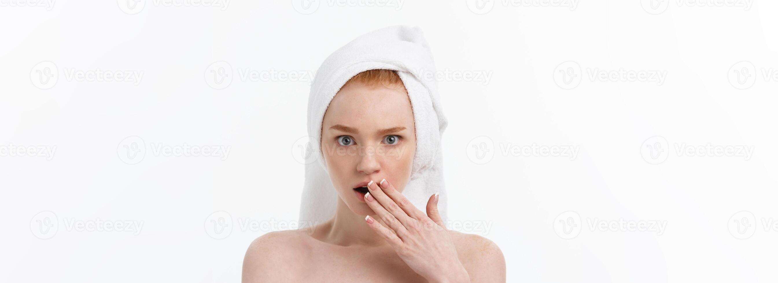 Surprised Beautiful Young Woman After Bath with A Towel On Her Head Isolated On white Background. Skin Care And Spa Theme. photo