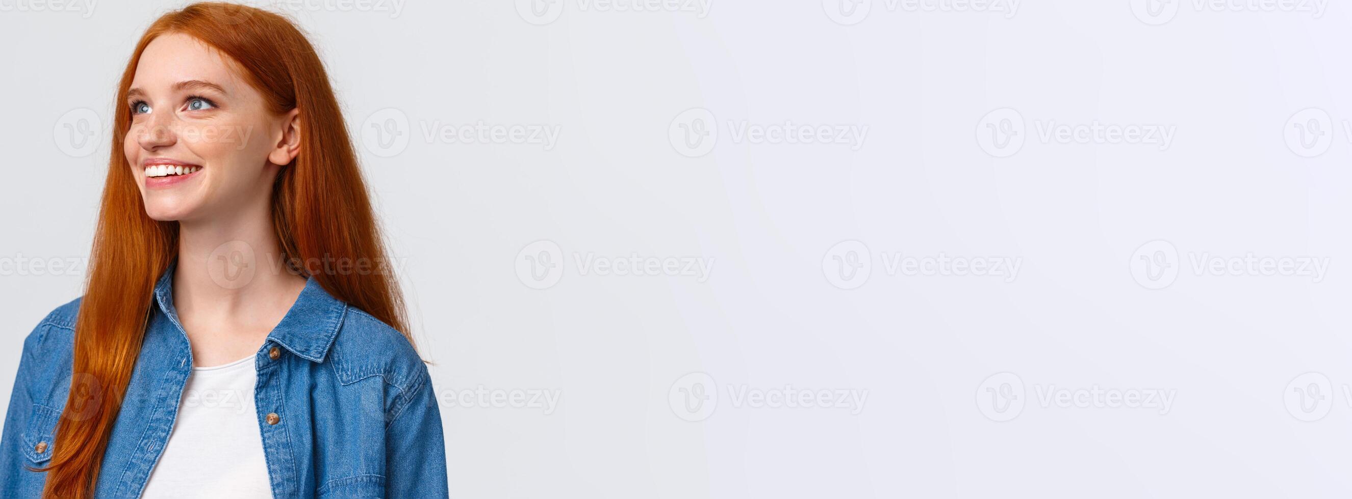 Close-up portrait dreamy and cute upbeat redhead woman seeing beautiful view, contemplate something wonderful, smiling and looking upper left corner delighted, white background photo