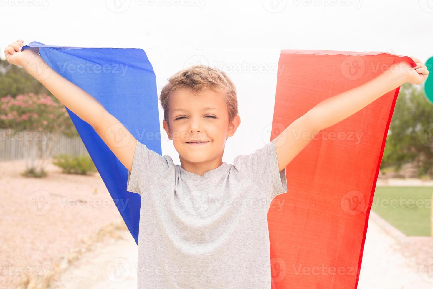 happy, cheerful boy holding france flag photo