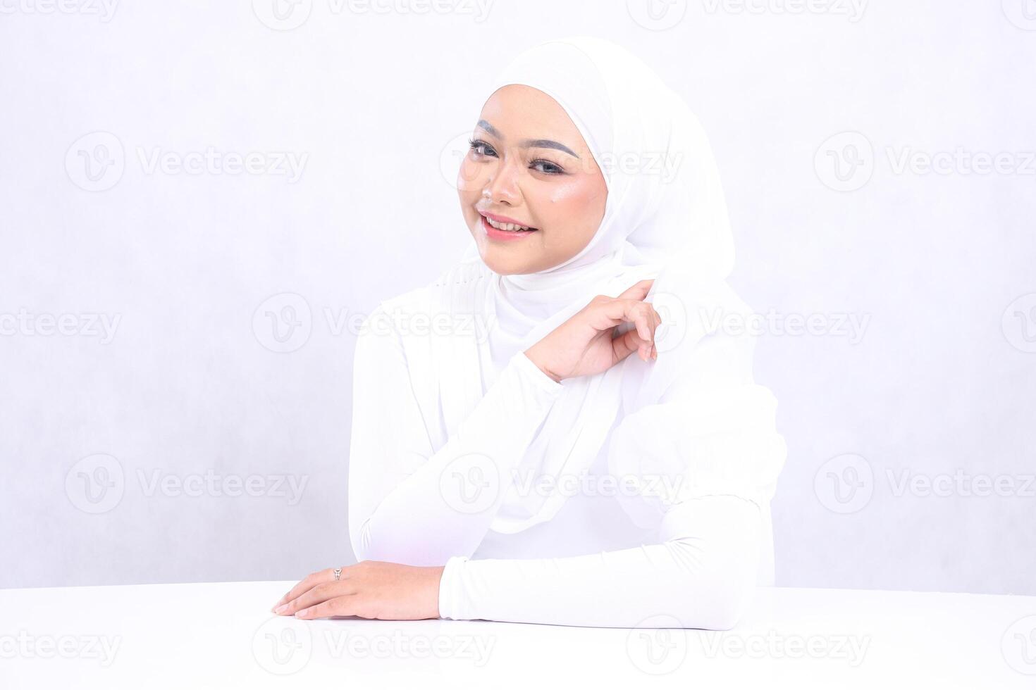The charm of a cheerful veiled girl with perfect and healthy radiant white skin, hands on the table and left arm isolated on a white background. Closeup of a face makeup for skincare, and care content photo