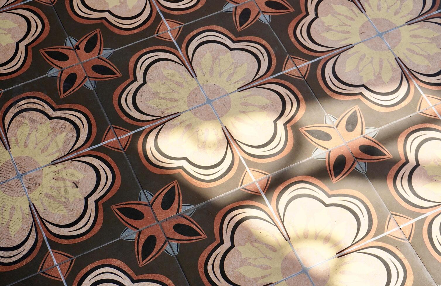 Abstract decorative brown and yellow floor tile floral pattern design isolated on horizontal ratio sun light and shadow shade background. photo