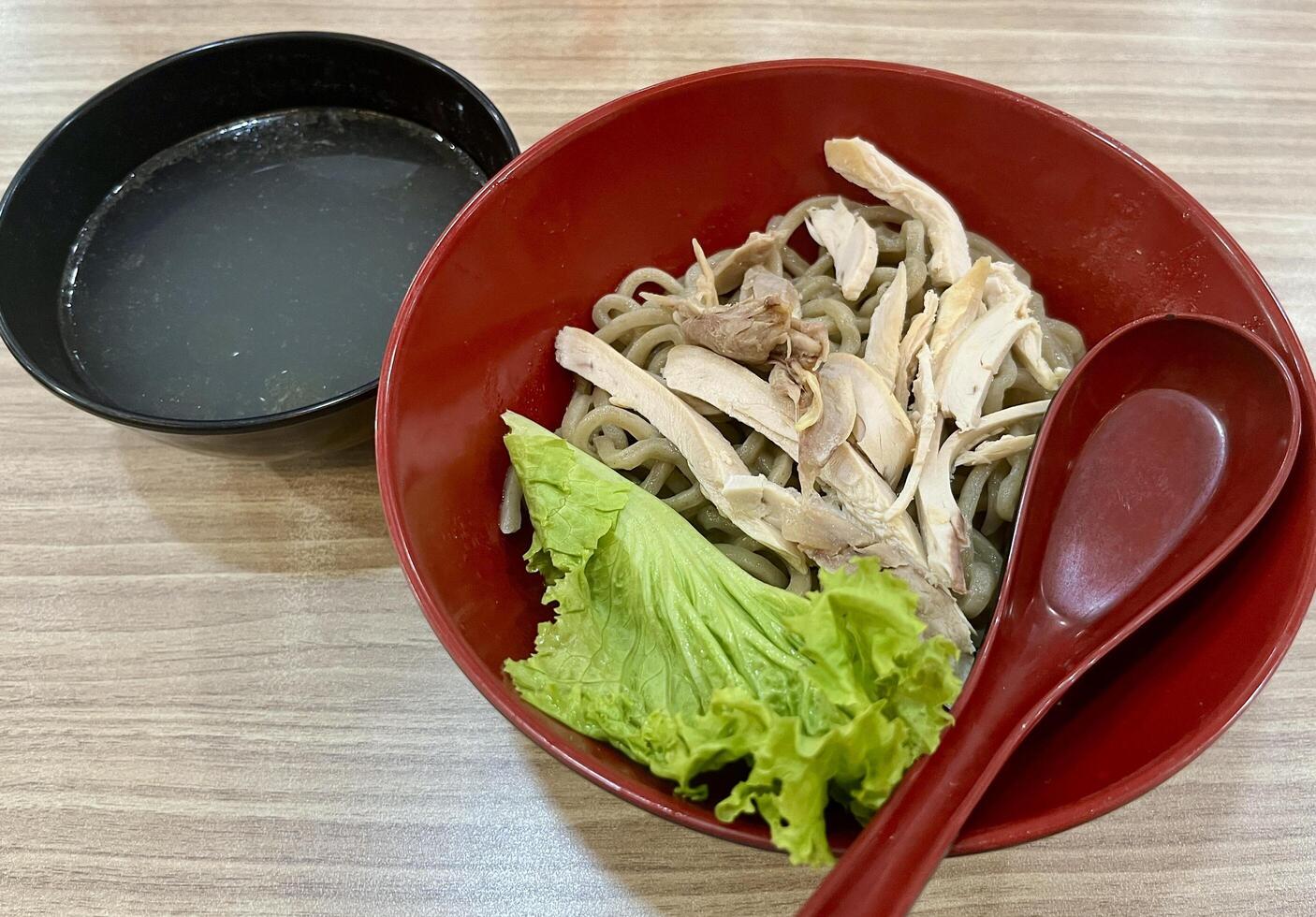 Chinese noodle with steamed chicken meat topping. Mie karet ayam rebus isolated on horizontal ratio wooden table background. photo
