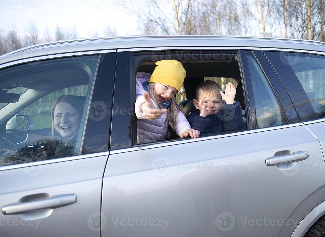 Happy family mother and two children goes to travel trip in the car photo
