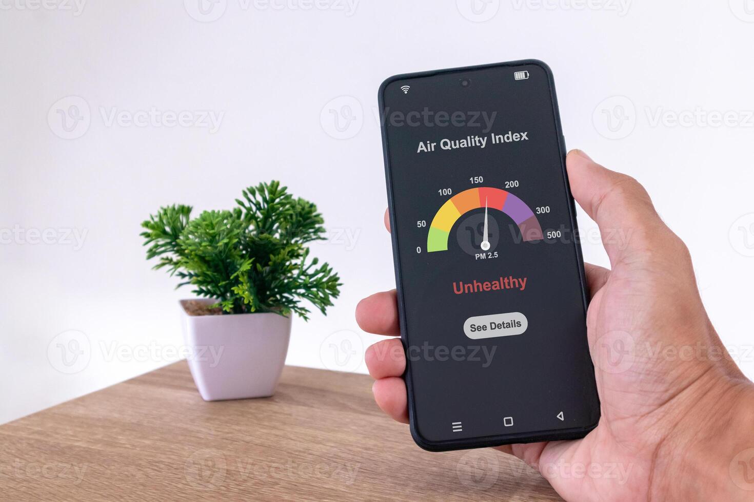 Man in room checking air quality index using a smartphone photo