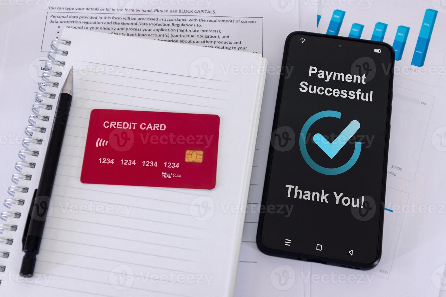 Office desk with credit card and smartphone with successful payment message on smartphone screen photo
