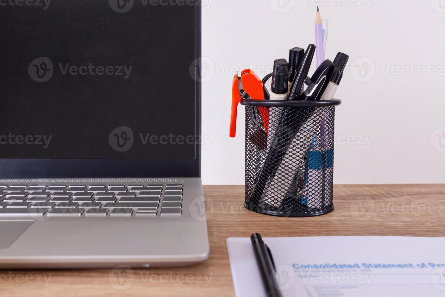 Close up view of desk workplace with stationery, laptop, and paperwork photo