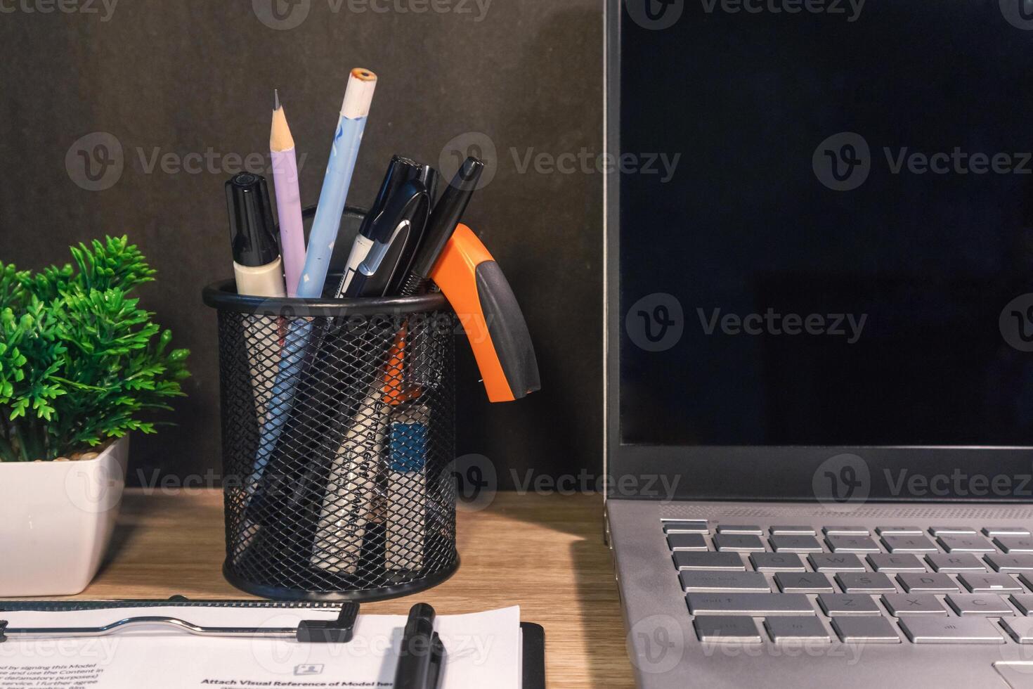 Close up view of workplace with note book, stationery, laptop, and flower photo