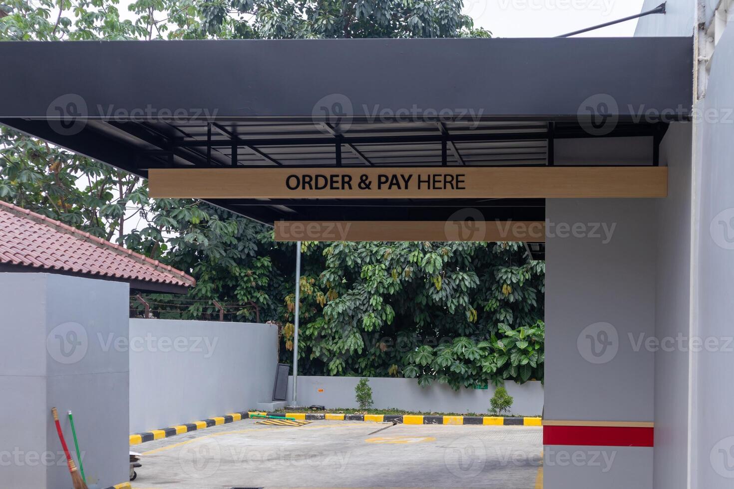 Drive thru lane at a fast food restaurant. Order and pay here signage. photo