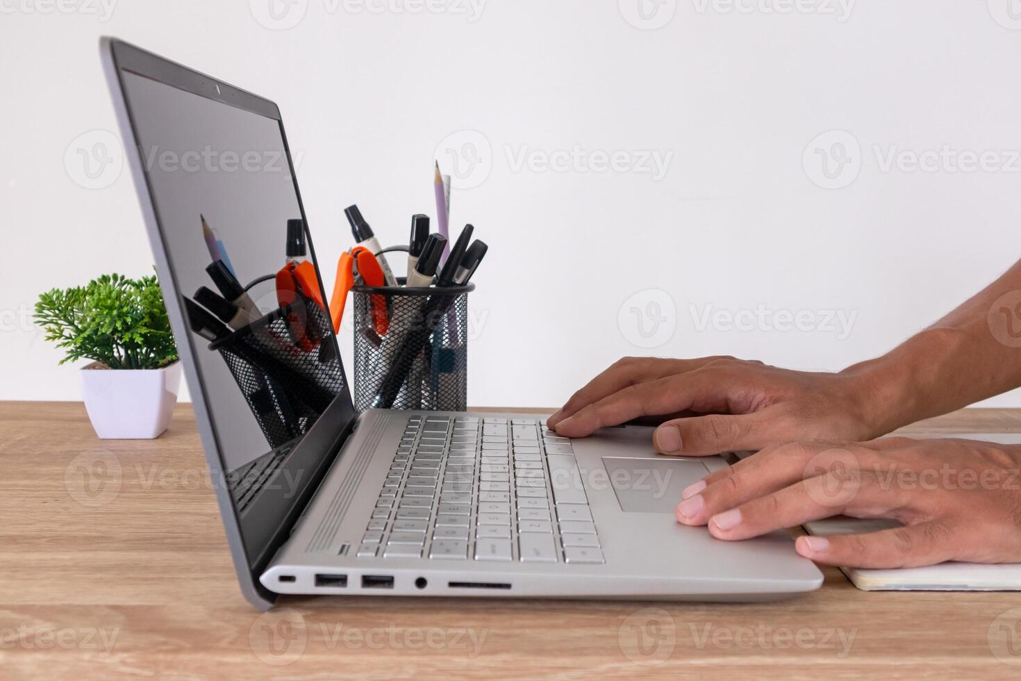 Side view of male hands on laptop computer at workplace. Man typing on laptop at his office desk. photo