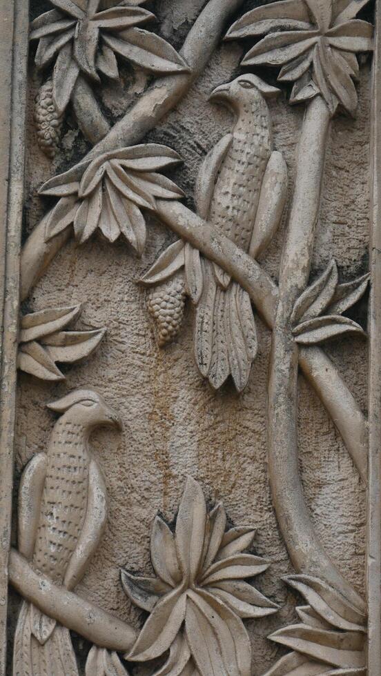 Marble stone carving with geometric, plant and bird motifs. Handmade. marble texture. nusantara motifs in the decoration of Orthodox churches. photo