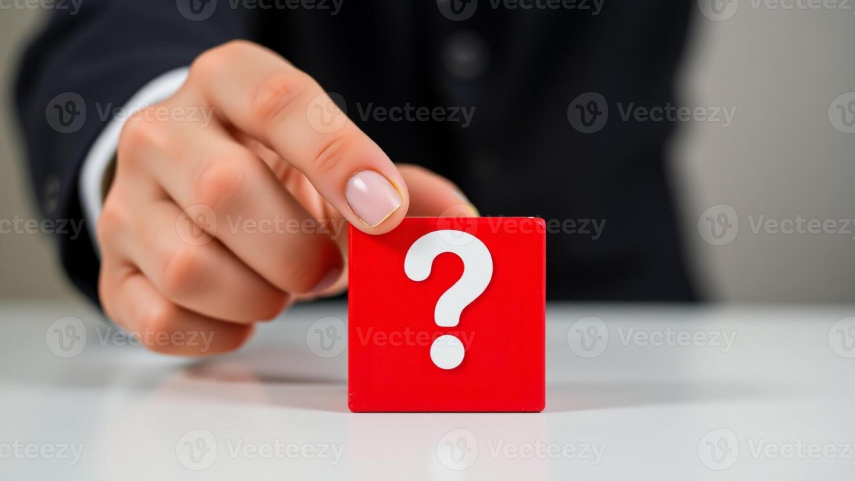 Close-up Of Person's Hand Holding White Question Mark On Red Block photo