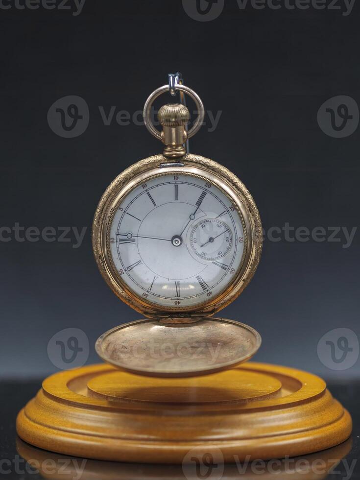 old pocket watch a family heirloom from several generations ago hanging in its display case face open with out the dome photo