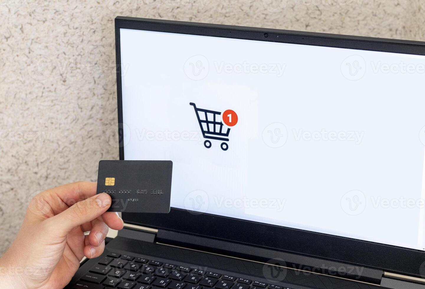 Shot of the man in the front of the laptop screen, holding credit card. Technology photo