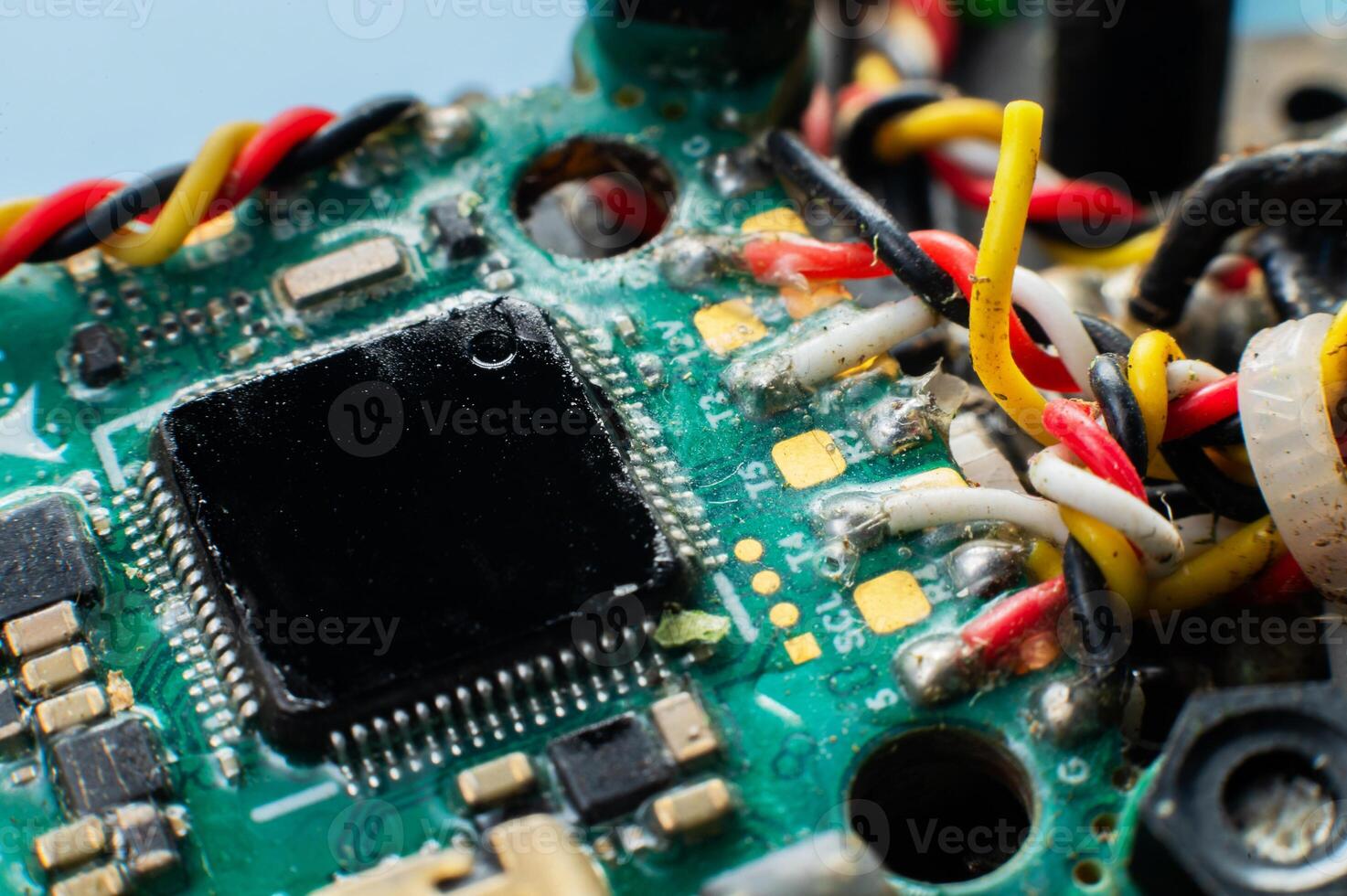 Close-up macro of drone flight controller microprocessor with broken wire. Microelectronics repair. photo