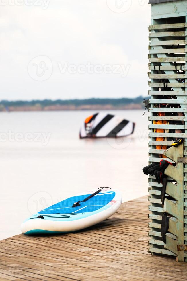A SUP board paddle board lies next to the storage at the paddle board station on the seashore photo