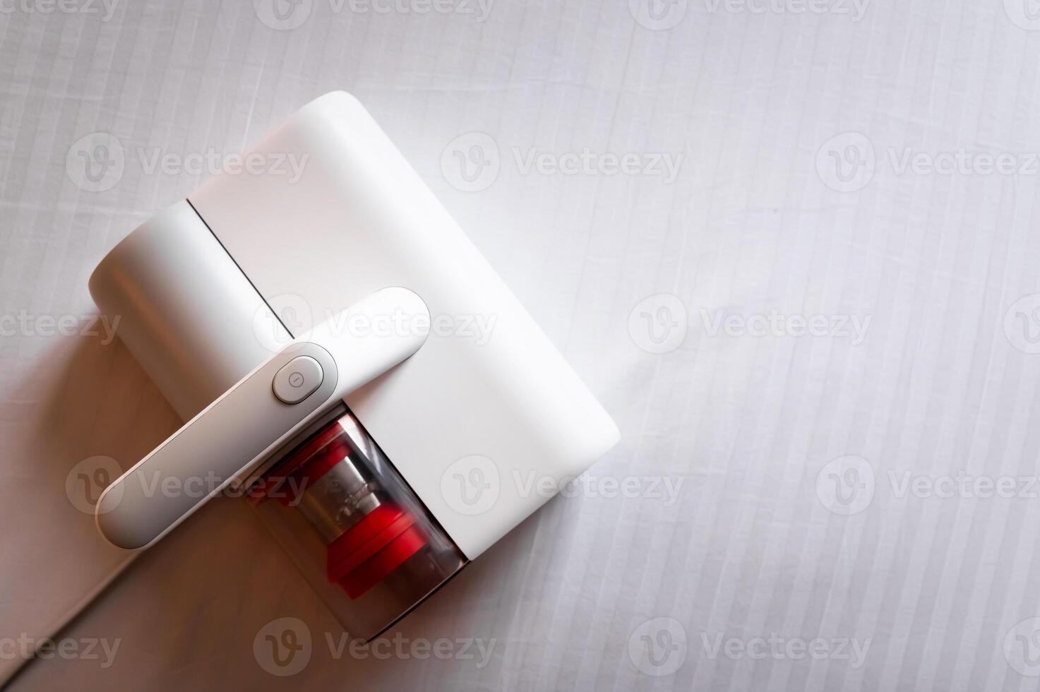 Vacuum cleaner for cleaning mattresses from mites with UV lamp and knocking out dust. Cleaning and disinfection of the mattress in the bedroom photo