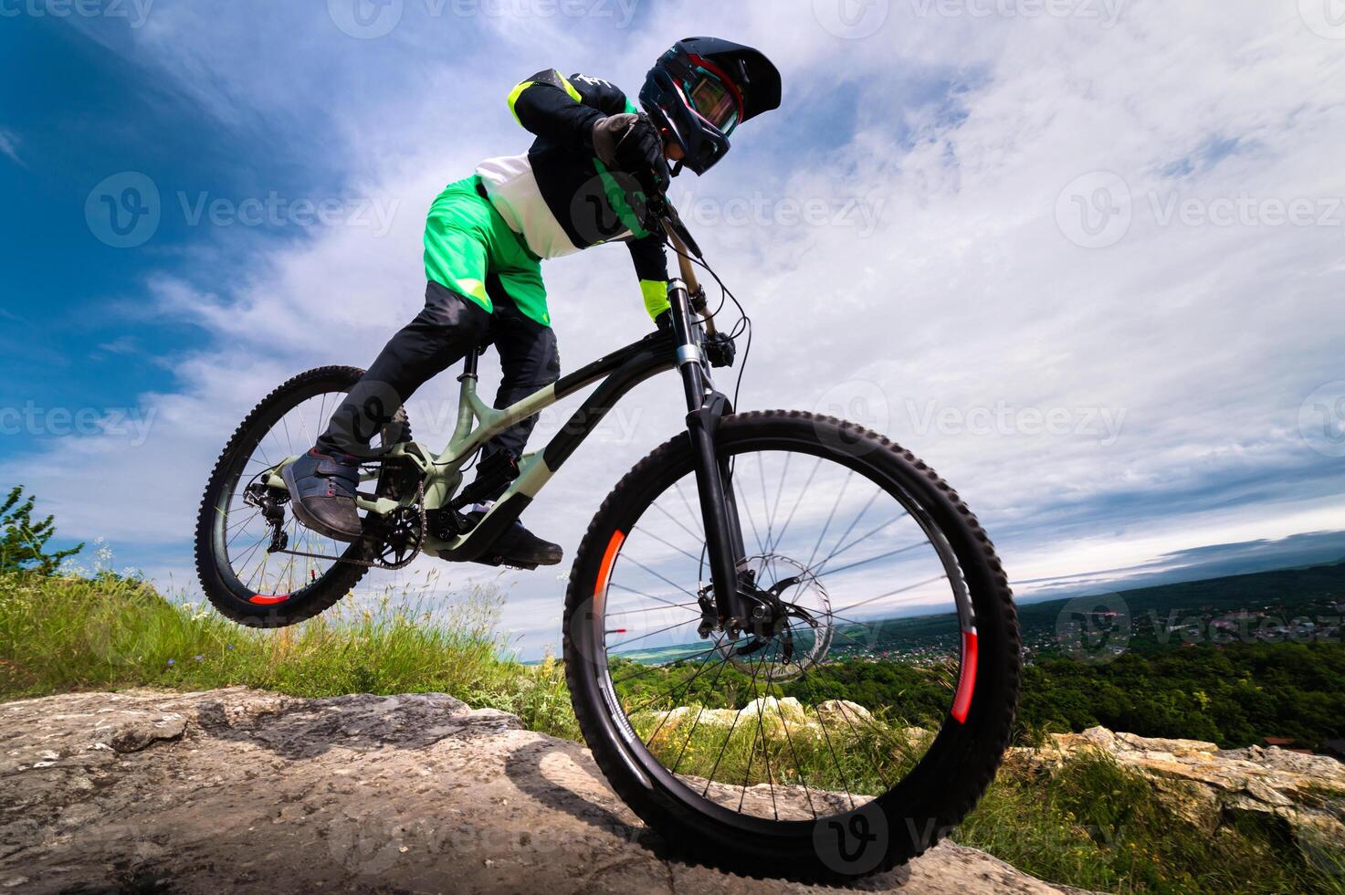 cyclist rides on his front wheel. Biker balances while riding a mountain bike. Risky riding on one wheel, performing a stunt photo