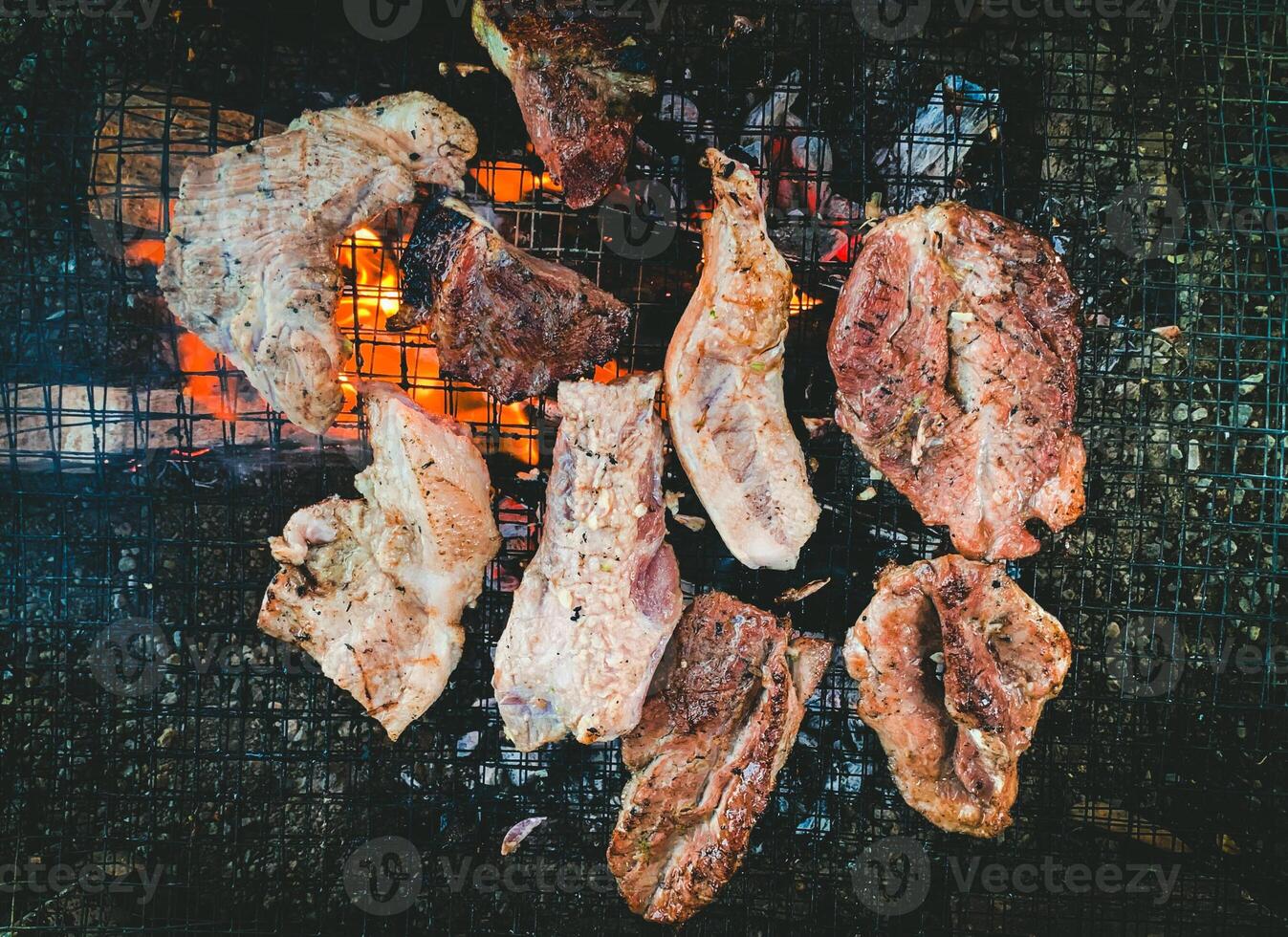 Grilled Meat on Barbecue, Closeup of Juicy Steaks and Pork Cooking Over Open Fire, High-Quality BBQ Stock Image for Food Photography and Culinary Concepts. photo