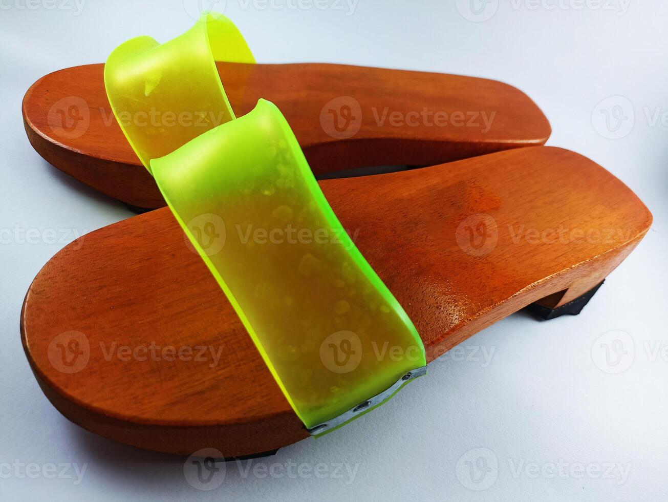 This is a pair of gapyak sandals with a white background. Made from wood, it is a traditional sandal from Indonesia that can be worn by both men and women photo