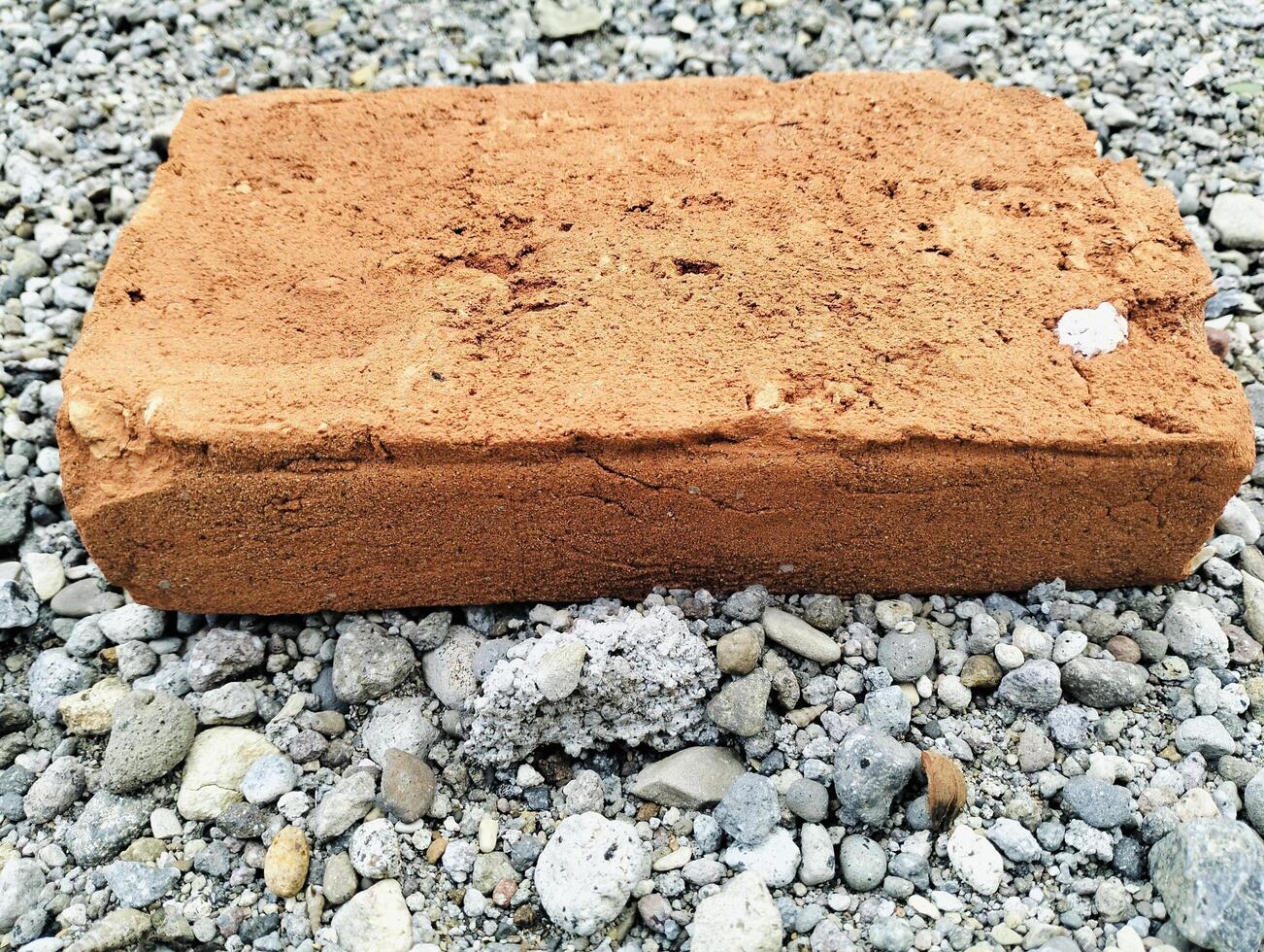 Rustic Clay Bricks Displaying Textures and Wear on Pebble Ground photo