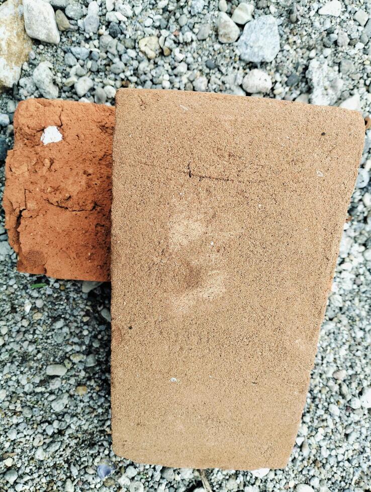 Rough Clay Bricks Over Gravel Background, Highlighting Construction Elements photo