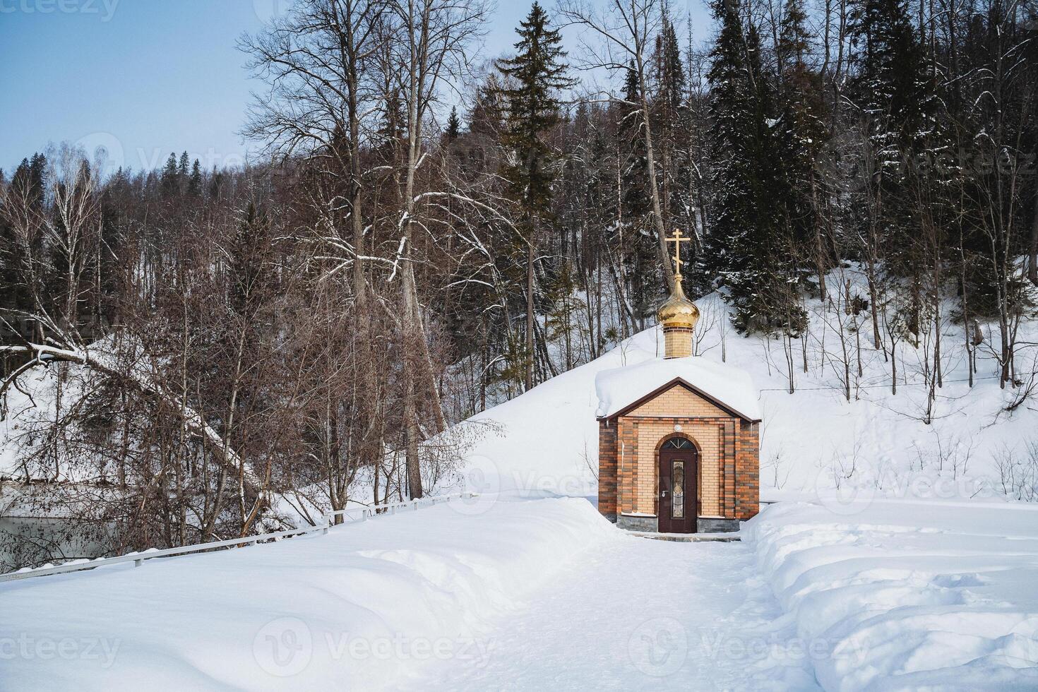 A small wooden church nestled in a snowy forest landscape photo
