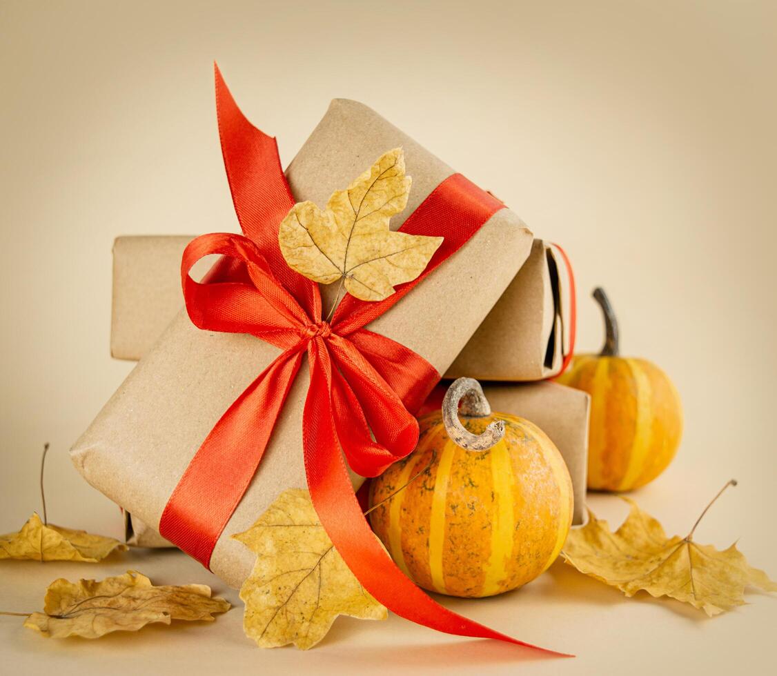 Autumn composition. Gift boxes, fresh pumpkins with autumn leaves on a light background. Autumn, Halloween, thanksgiving day concept. photo