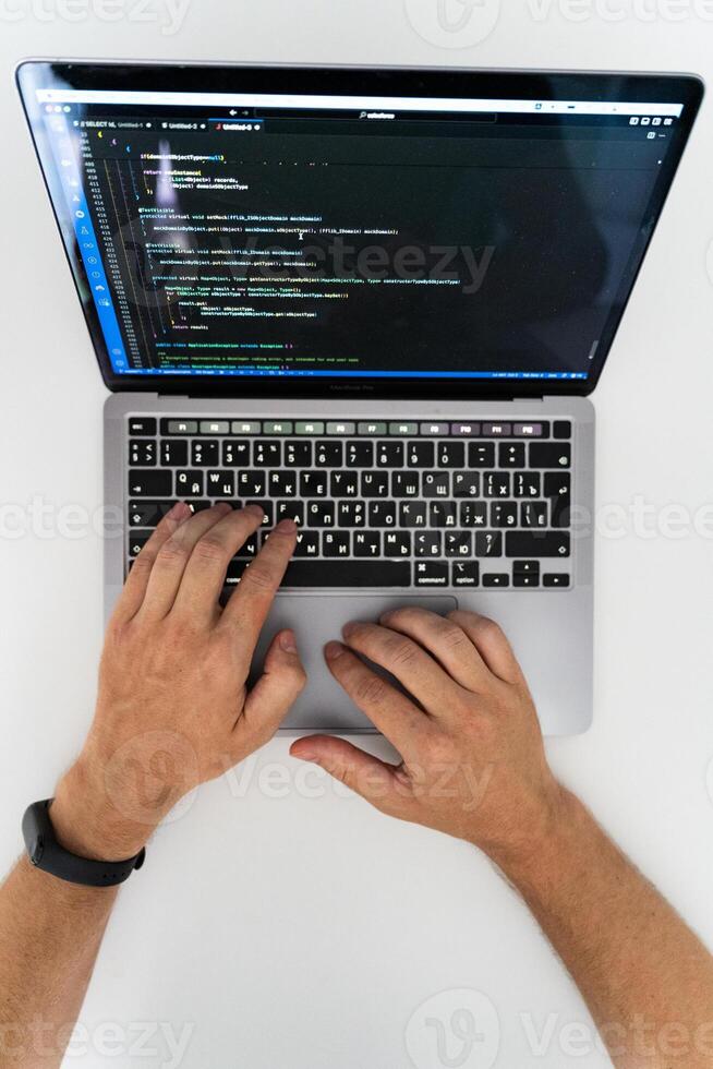 An overhead view of the hands of a man working at a computer photo