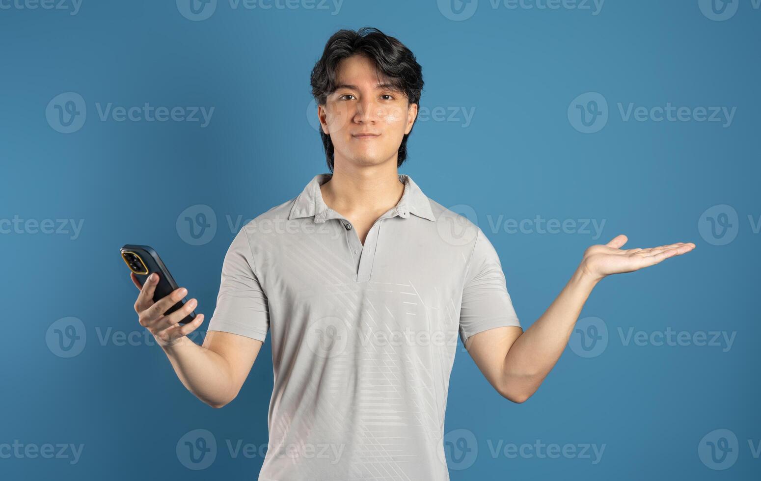 Portrait of asian man posing on blue background photo