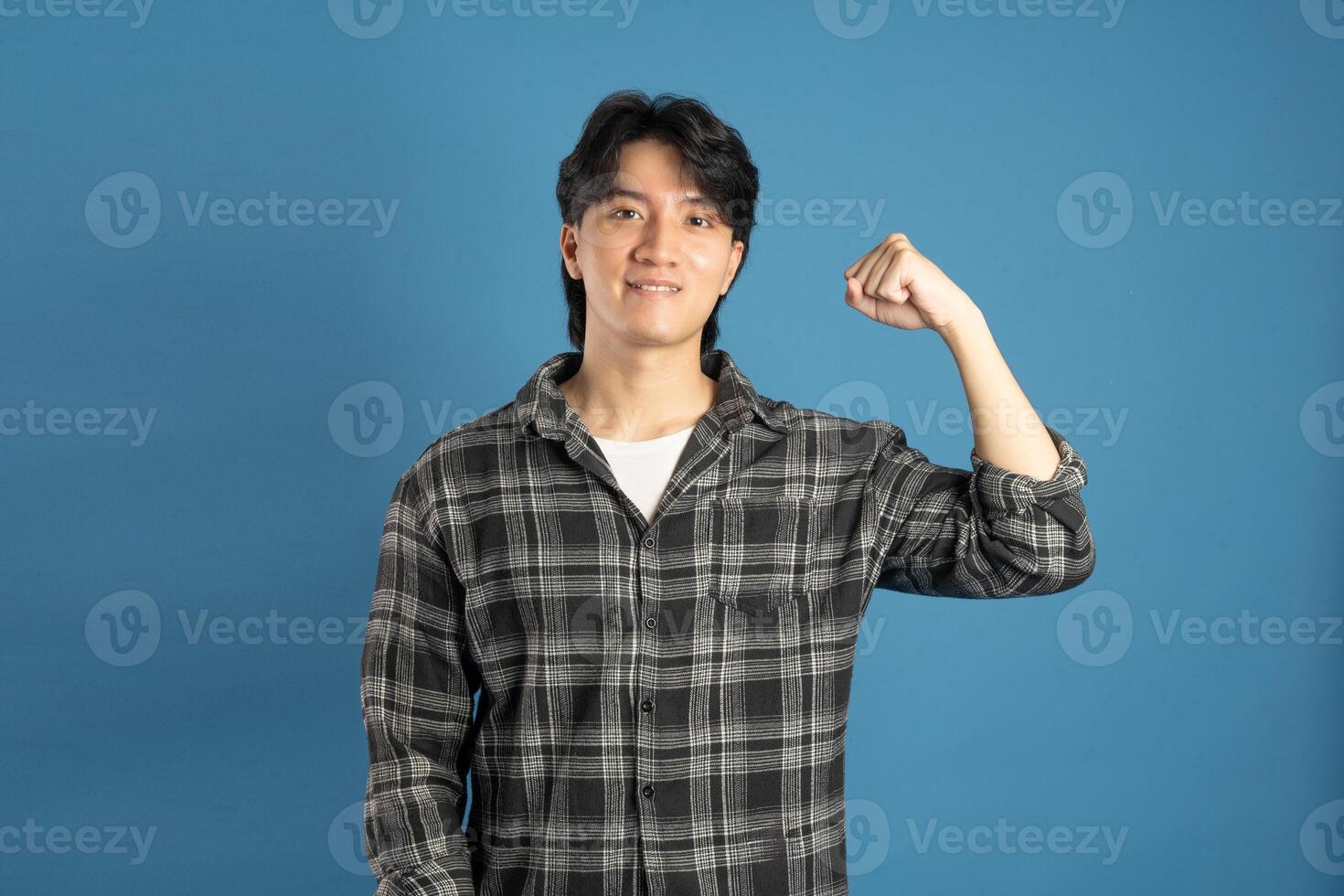 Portrait of Asian male student posing on blue background photo