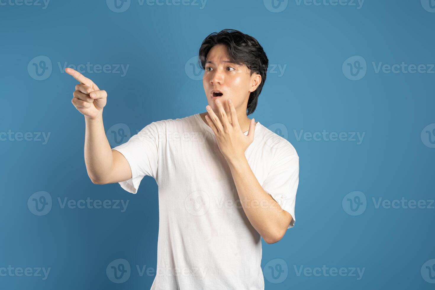 Portrait of asian man posing on blue background photo