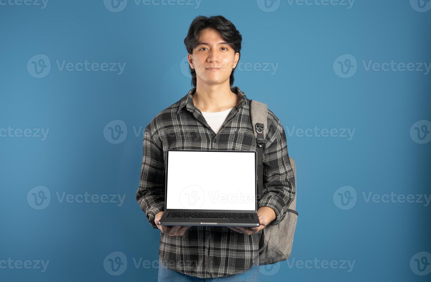 Portrait of Asian male student posing on blue background photo