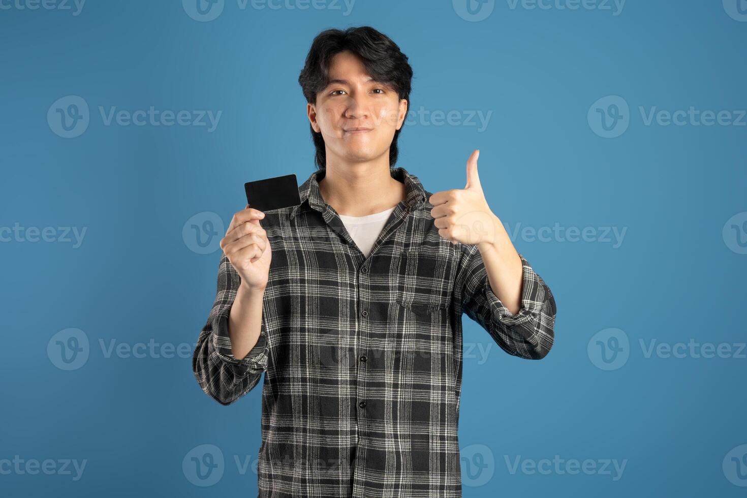 Portrait of Asian male student posing on blue background photo