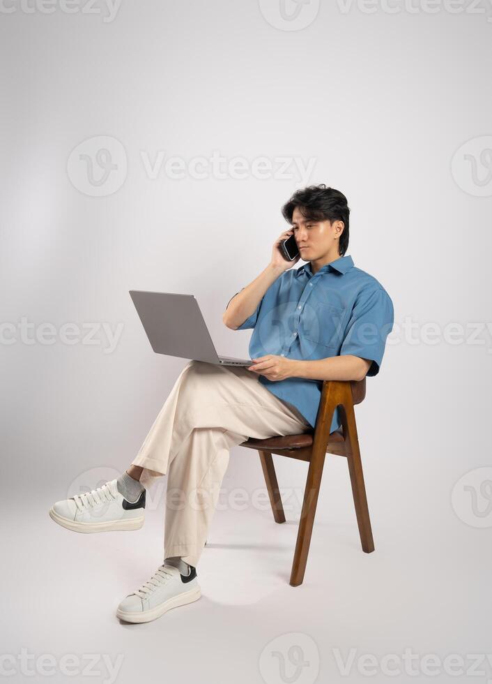 Portrait of young Asian business man sitting in chair, isolated on white background photo