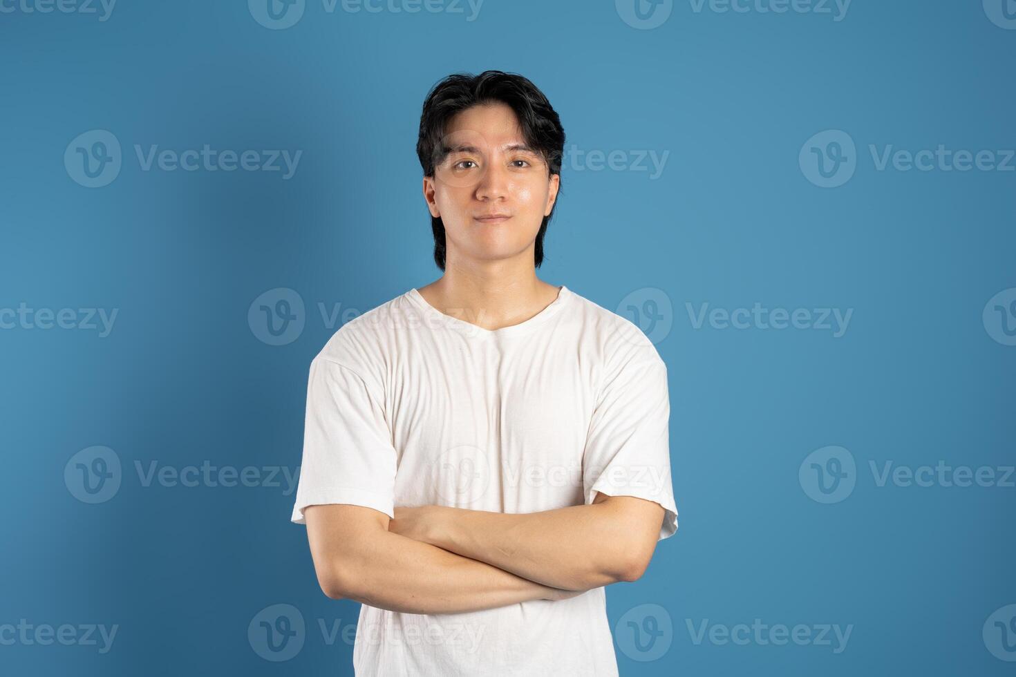 Portrait of asian man posing on blue background photo
