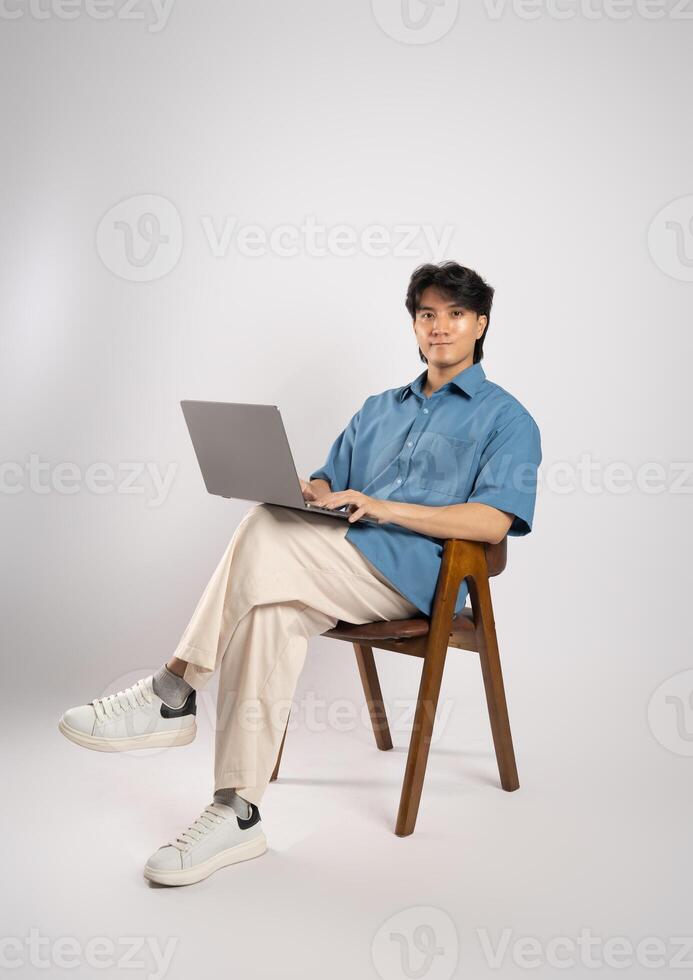 Portrait of young Asian business man sitting in chair, isolated on white background photo