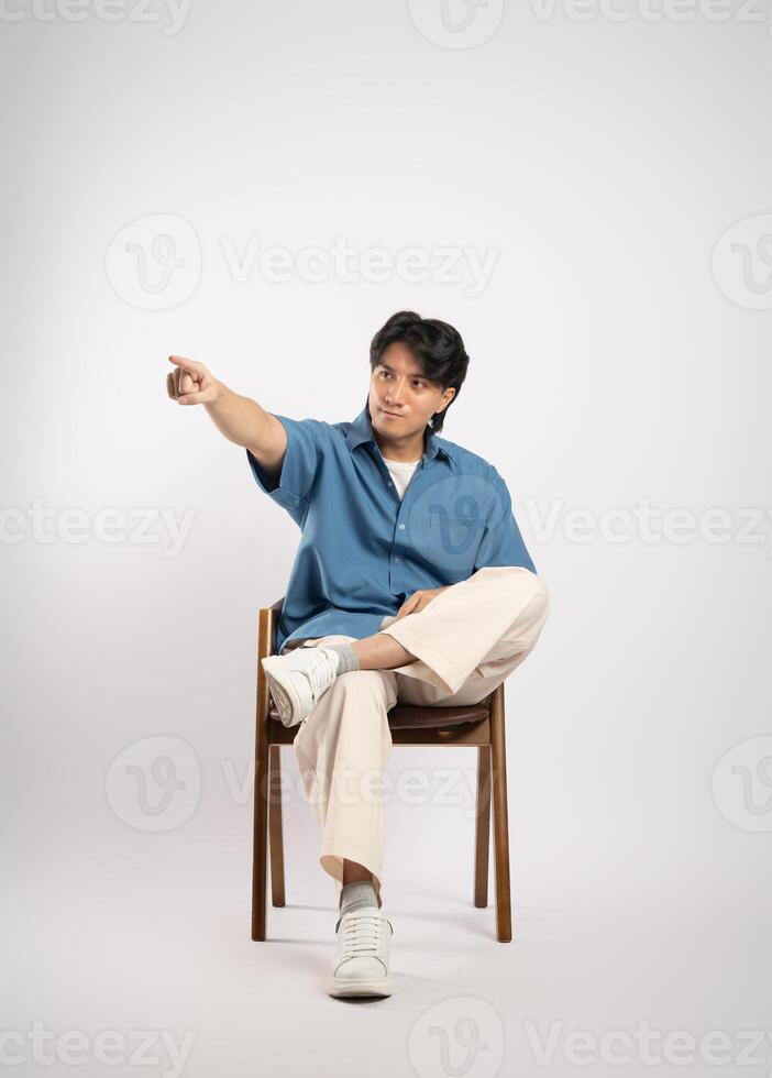 Portrait of young Asian business man sitting in chair, isolated on white background photo