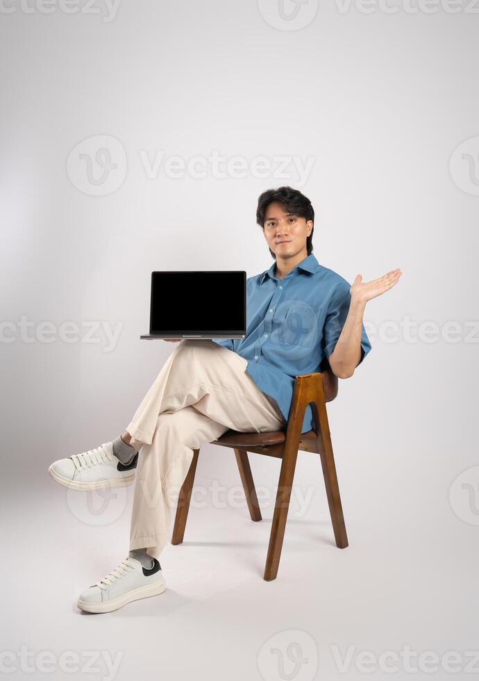 Portrait of young Asian business man sitting in chair, isolated on white background photo