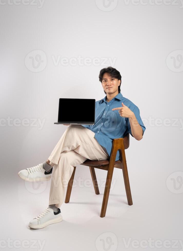 Portrait of young Asian business man sitting in chair, isolated on white background photo