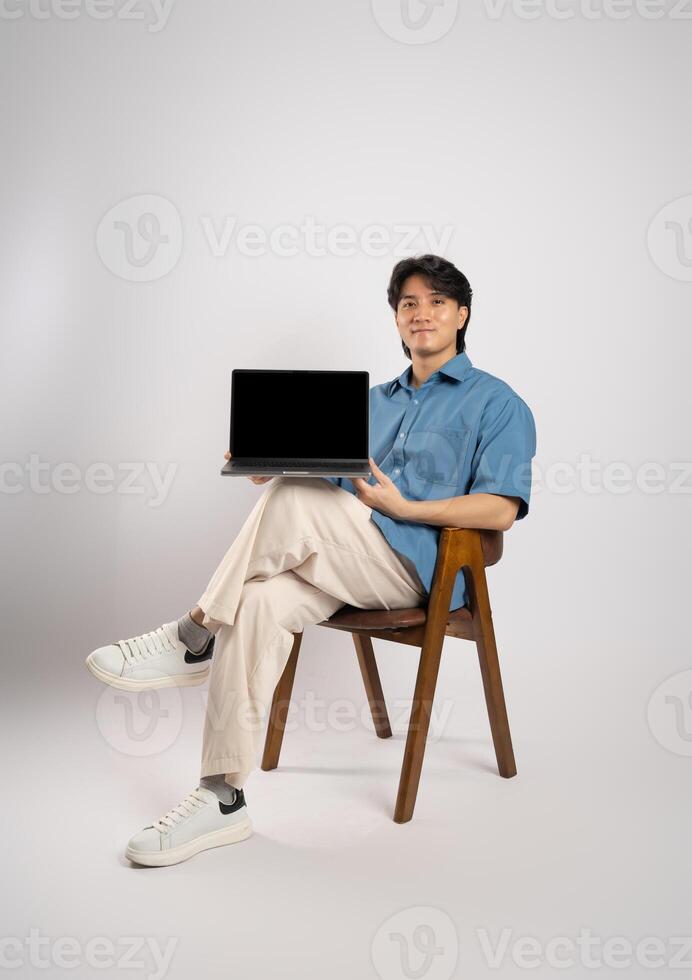Portrait of young Asian business man sitting in chair, isolated on white background photo