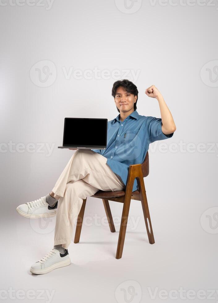 Portrait of young Asian business man sitting in chair, isolated on white background photo