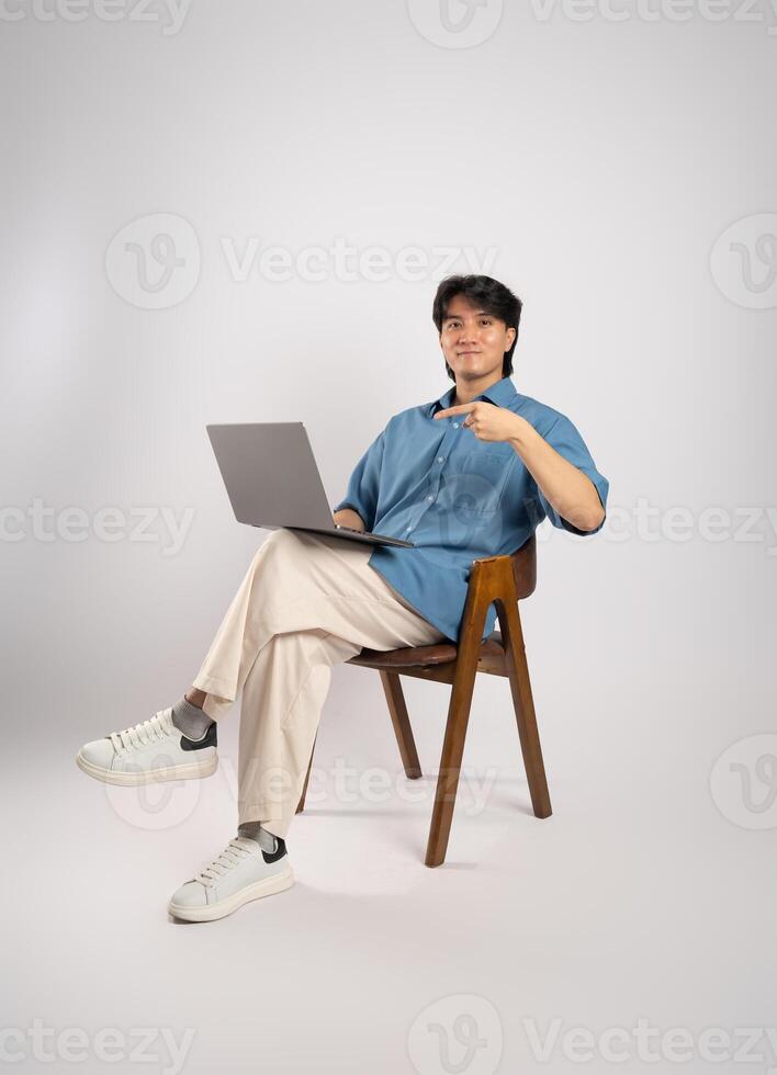 Portrait of young Asian business man sitting in chair, isolated on white background photo