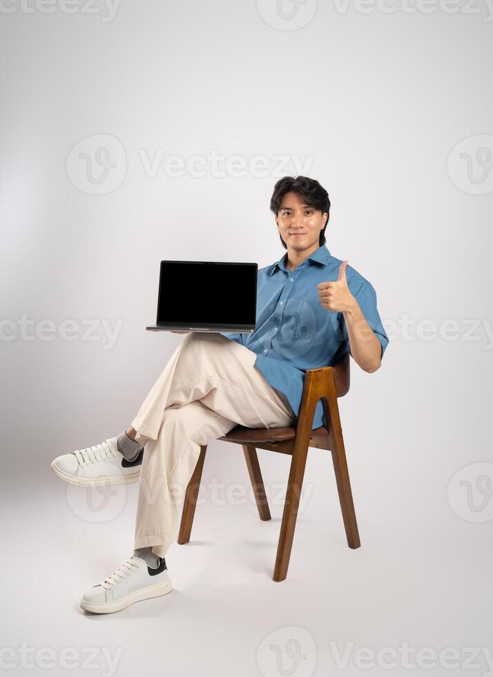 Portrait of young Asian business man sitting in chair, isolated on white background photo