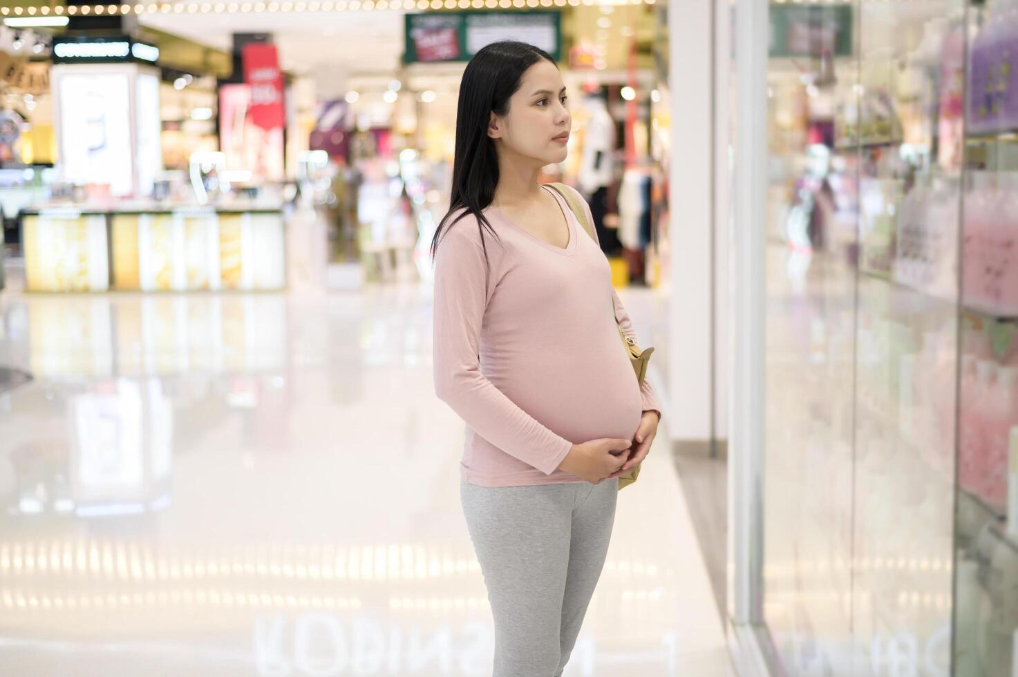 Pregnant woman shopping in the mall center photo