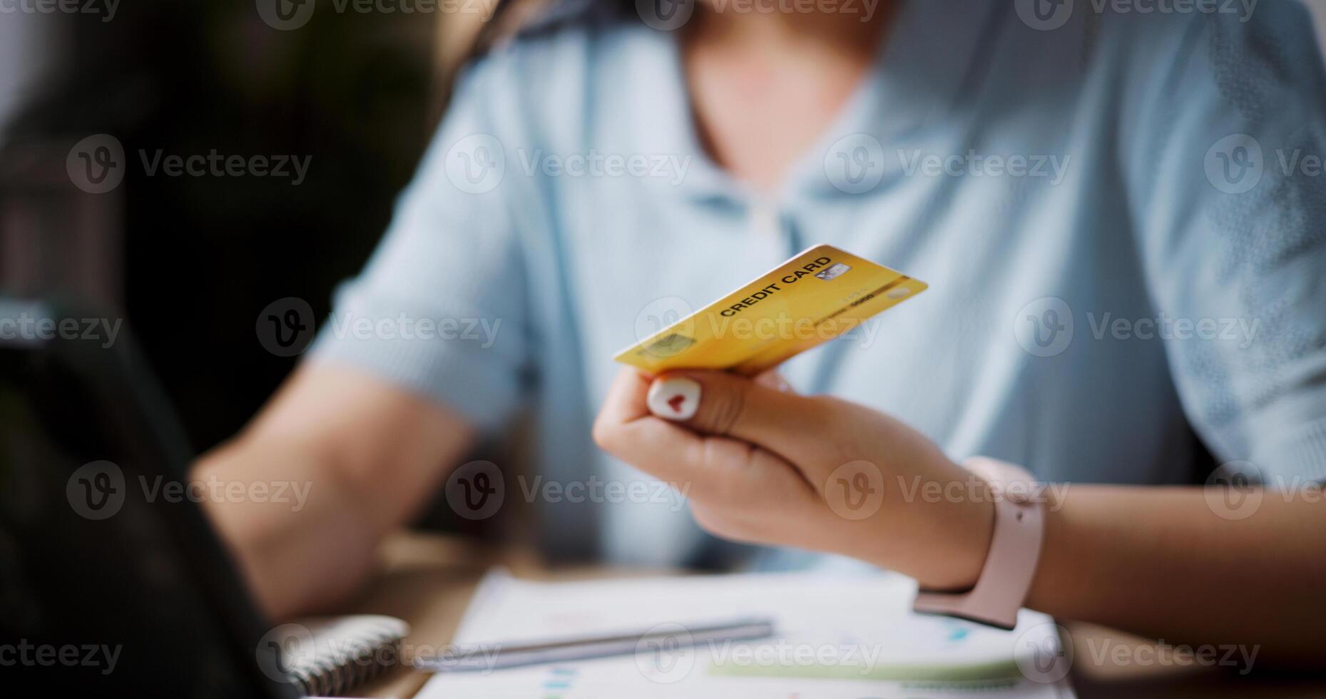 Relaxed female freelancer sitting at desk shopping online using a credit card and paying via digital tablet in home office. Work from home photo