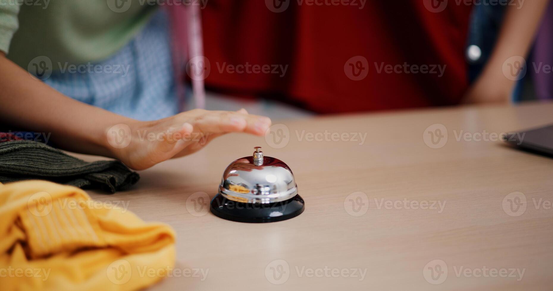 Selective focus, Young asian woman live-streamed selling clothes and pressed a bell to attract customers' attention in home studio. Remote buying, Online shopping. photo
