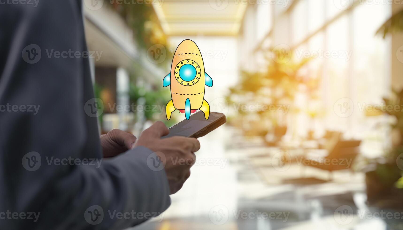 Businessman holding smartphone with rocket icon on screen photo