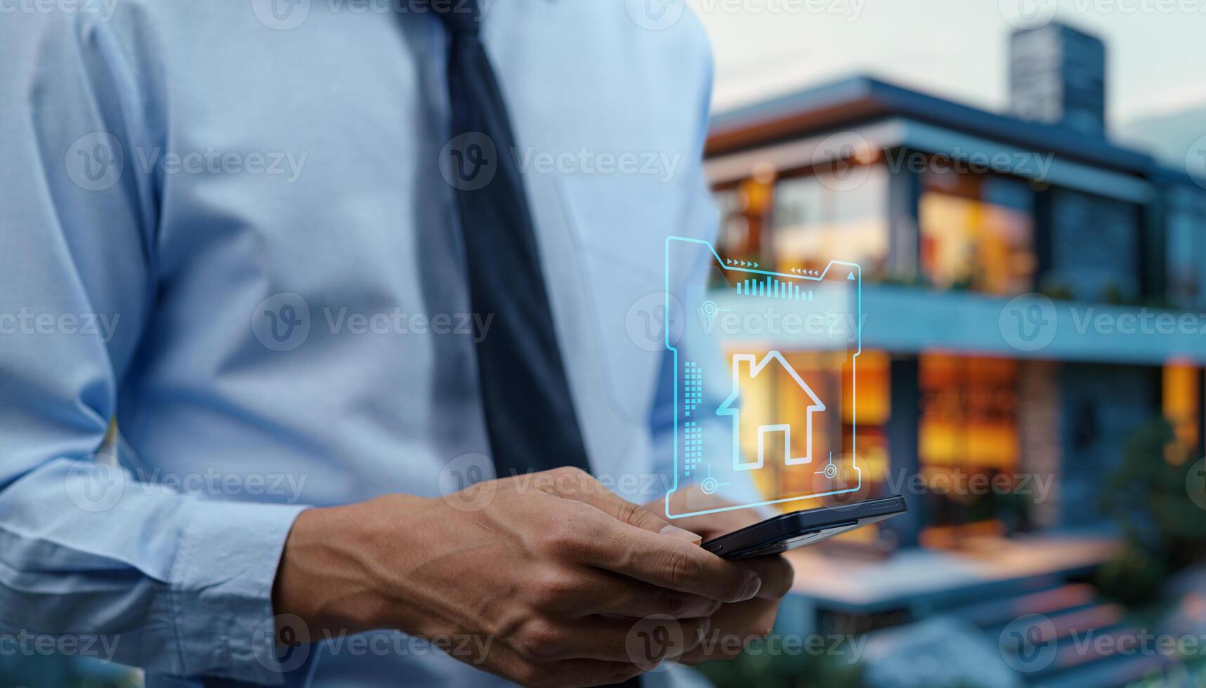 A man in a business shirt and tie holding a smartphone with a house icon on it photo