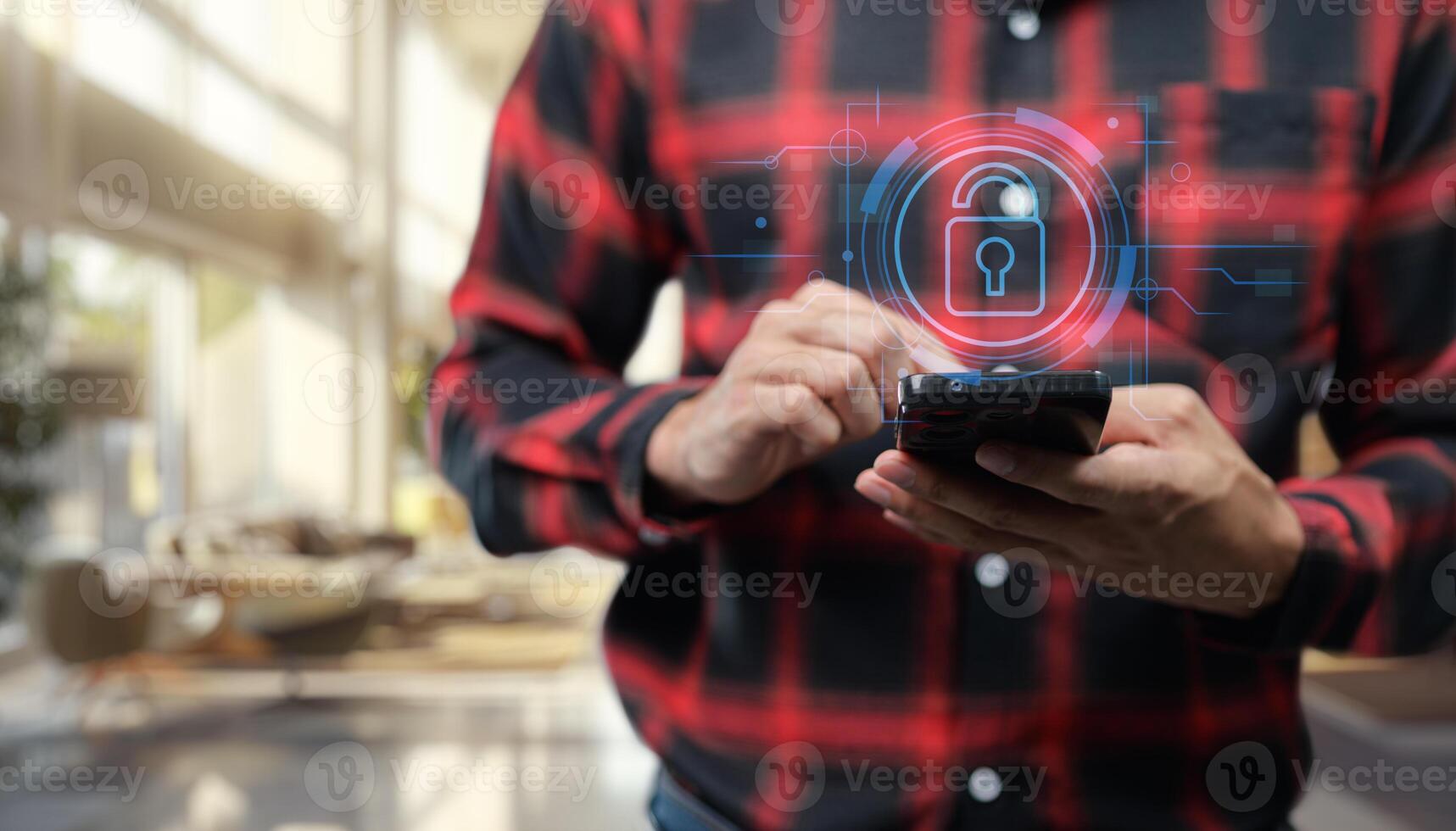 A man in a plaid shirt is holding a smart phone with a padlock icon on it photo